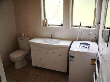 a bathroom with a sink and a toilet at Whangarei Holiday Houses in Whangarei