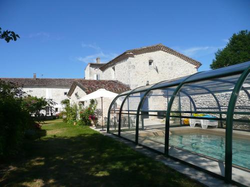 a building with a pool in front of a house at Chambres d'Hôtes Saint Roch in Tournecoupe