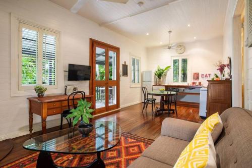 een woonkamer met een bank en een tafel bij Coco's Cottage in the Byron Bay Hinterland in Bangalow
