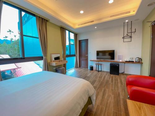 a bedroom with a large bed and a red chair at Zhaohong homestay in Yuchi