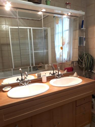 a bathroom with two sinks and a large mirror at Paris Magic - Villepinte Exhibition Center in Sevran