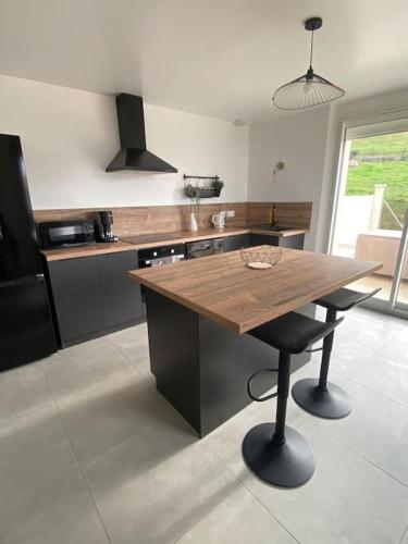 - une cuisine avec une table en bois et un comptoir dans l'établissement Maison au cœur de la campagne, à Saint-Romans