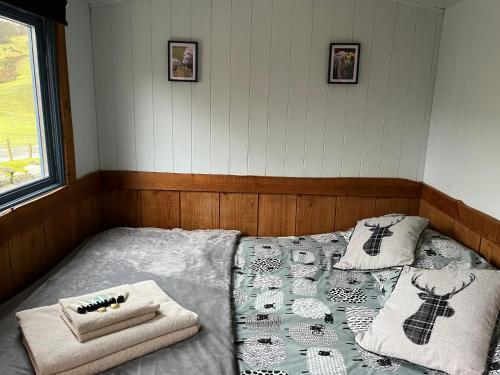 a bedroom with a bed with two towels on it at Berwyn Shepherds Hut in Wrexham