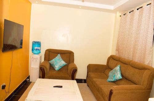 a living room with two chairs and a couch at Fully furnished one bedroom in Thika Cbd in Thika