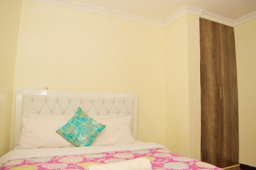a bedroom with a white bed with a blue pillow at Fully furnished one bedroom in Thika Cbd in Thika