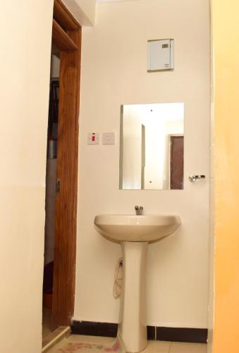 a bathroom with a sink and a mirror at Fully furnished one bedroom in Thika Cbd in Thika