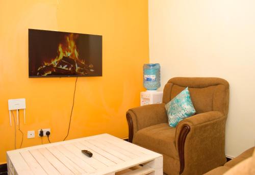 a living room with a chair and a fireplace at Fully furnished one bedroom in Thika Cbd in Thika