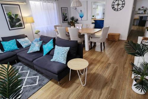 a living room with a couch and a table at Peaceful Getaway - Stylish, Newly Updated House in Brisbane