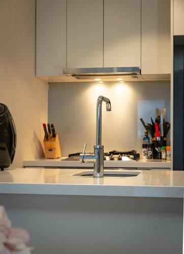 a kitchen counter with a sink and aaucet at Valentine Sweet Monlando 3 queens private spa pool gym sauna and parking Sleeps 6 in Melbourne