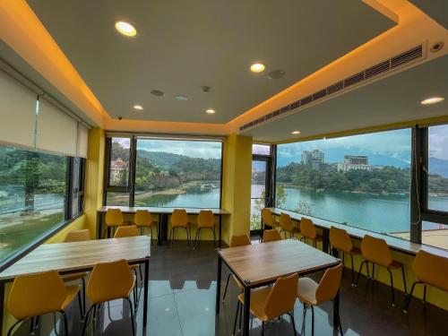 a restaurant with tables and chairs and large windows at Zhaohong homestay in Yuchi