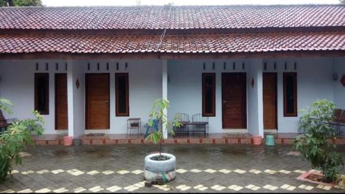 a white house with a red roof at Umah isun guests house in Banyuwangi