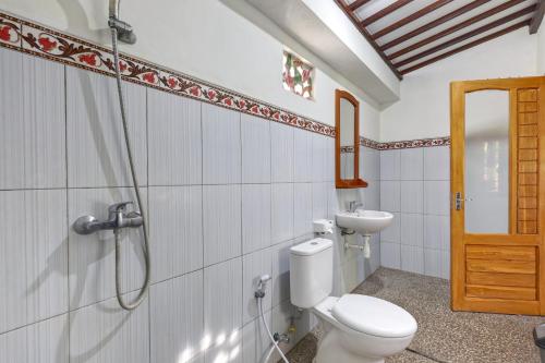 a bathroom with a toilet and a shower at Putri Nusa Beach in Nusa Penida