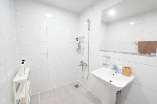 a white bathroom with a sink and a shower at Mapo Villa in Shinchon in Seoul