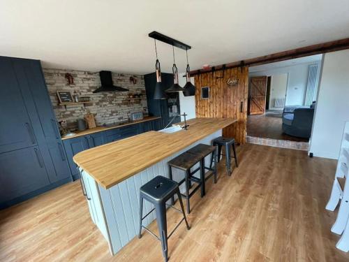 a kitchen with a counter and stools in a room at Sundial Cottage, Stunning 3 Bed Cottage with Hottub in Skelton