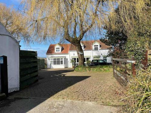 a large white house with a tree in front of it at Sundial Cottage, Stunning 3 Bed Cottage with Hottub in Skelton