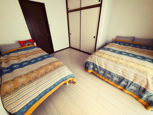 2 nebeneinander sitzende Betten in einem Schlafzimmer in der Unterkunft yadori TEN 宿り　甸 
