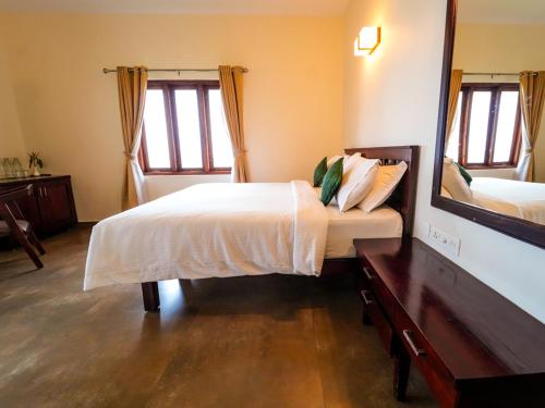 a bedroom with a bed and a large mirror at Solaris Varkala Beach Resort By VOYE HOMES in Varkala