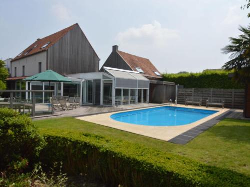 a swimming pool in the yard of a house at Splendid villa in Flemish Ardennes with pool in Zottegem