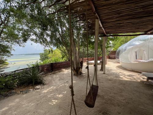 a hammock under a building with a view of the water at Rock and Sea Resort in Watamu