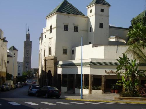 a white building with a clock tower on a street at Appartement Panoramique in Casablanca