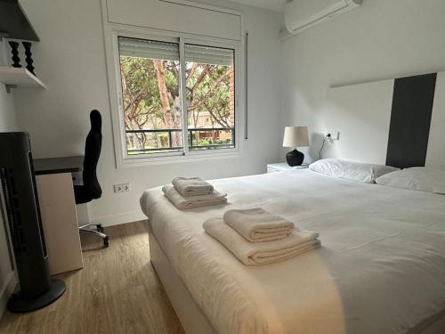 a white bedroom with a bed with towels on it at Gavà Mar: Villa Lujo 6 Pax in Gavà