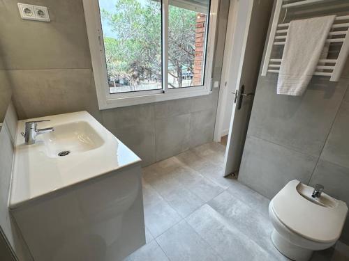 a bathroom with a white sink and a toilet at Gavà Mar: Villa Lujo 6 Pax in Gavà