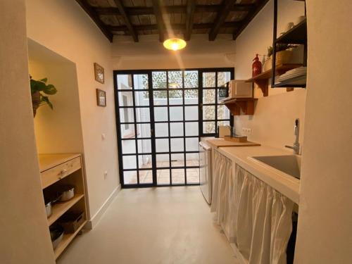 a kitchen with a sink and a large window at Casa del Sacramento - CASITA CON ENCANTO in Medina Sidonia