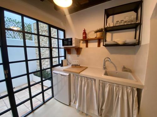 a kitchen with a sink and a large window at Casa del Sacramento - CASITA CON ENCANTO in Medina Sidonia