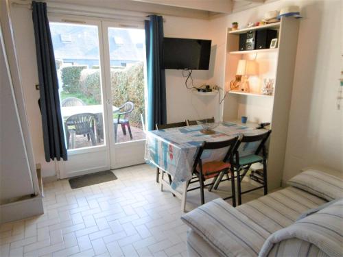 un salon avec une table et des chaises et une fenêtre dans l'établissement Maisonnette 3 pièces 4 personnes à 50 m du port de St Jacques - SERVANE, à Sarzeau