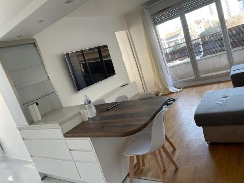 une pièce avec une table, des chaises et une télévision dans l'établissement Apparemment colombes, à Colombes