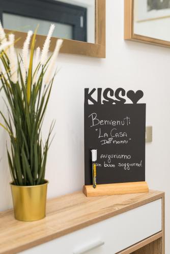 a chalkboard sign on a shelf next to a plant at La Casa dei Nonni in Isola del Gran Sasso dʼItalia