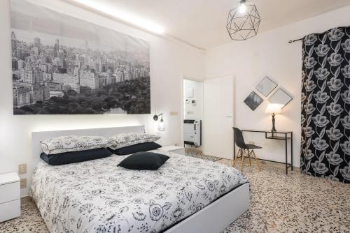 a bedroom with a white bed and a black and white picture at La Casa dei Nonni in Isola del Gran Sasso dʼItalia