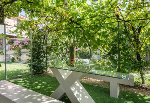 a glass table in front of a tree at La Casa dei Nonni in Isola del Gran Sasso dʼItalia