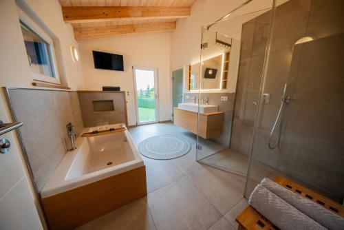uma grande casa de banho com um lavatório e um chuveiro em Ferienhaus Escherich em Büchlberg