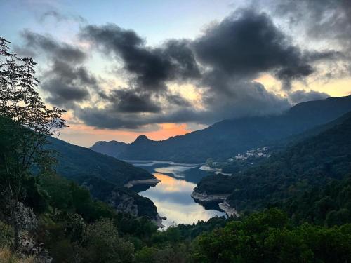 a view of a river in a valley with clouds at Côté Lac Tolla in Tolla