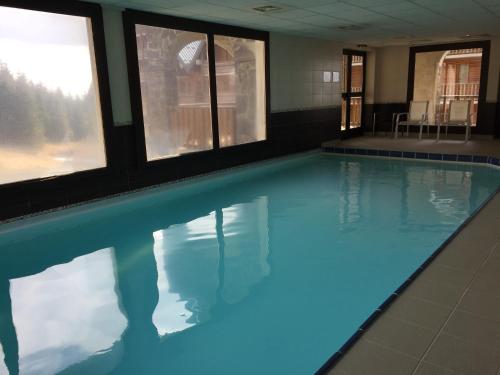 - une grande piscine avec éclairage bleu dans un bâtiment dans l'établissement Lama-Gîte-des-Puys T3 Lamadalet, vue sud, terrasse, parking privé, à Super-Besse