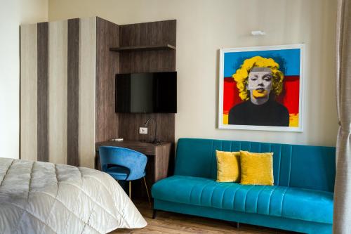 a bedroom with a blue couch and a painting at BAYRIA HOME in Bari