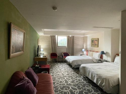 una camera d'albergo con due letti e un divano di 高第商旅 Gaudi Hotel a Kaohsiung
