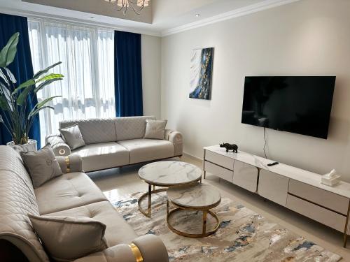 uma sala de estar com um sofá e uma televisão de ecrã plano em Dunya Tower Luxury and 2 min walk to Dubai Mall and Burj Khalifa em Dubai