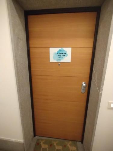 a wooden door with a sign on it at Lo Chalet del Golf Club in Tarvisio
