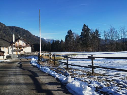 einen Zaun an der Seite einer Straße mit Schnee in der Unterkunft Lo Chalet del Golf Club in Tarvis