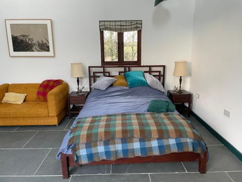een slaapkamer met een bed en een bank bij Tresahor Studio in Falmouth