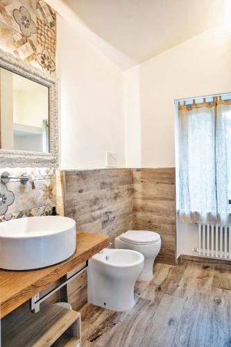 a bathroom with a sink and a toilet and a mirror at Villa Giuliana in Arezzo
