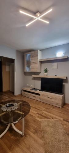 ein Wohnzimmer mit einem Deckenventilator und einem Tisch in der Unterkunft Apartmaji Medved, brezplačno parkiranje in Tacen