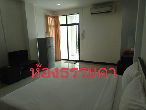 a living room with a refrigerator and a window at โรงแรมสบายเพลส (หินสองก้อน) in Lop Buri