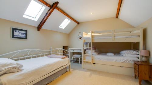 two bunk beds in a attic bedroom with skylights at Swn Y Mor in Port-Eynon