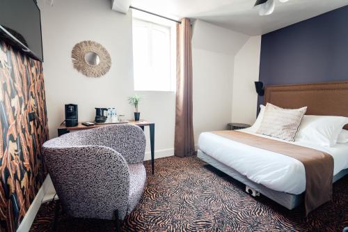 a bedroom with a bed and a chair and a window at La villa 10 HÔTEL SPA in Étretat