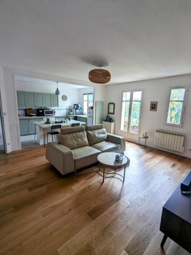 un salon avec un canapé et une table dans l'établissement Appartement - jardin 3 pièces, à Carrières-sous-Poissy