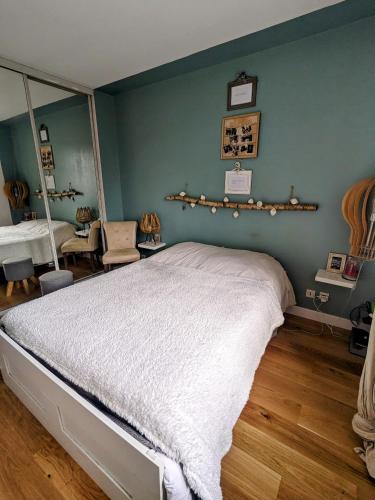 une chambre avec un grand lit et un miroir dans l'établissement Appartement - jardin 3 pièces, à Carrières-sous-Poissy