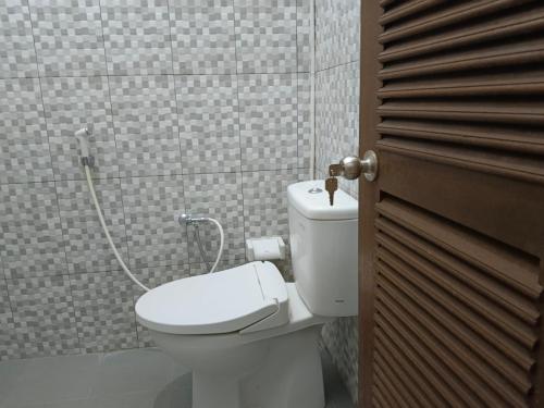 a bathroom with a toilet and a shower at Jepun Inn in Padangbai